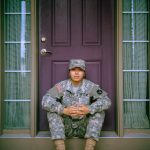United States military member sitting on home front step